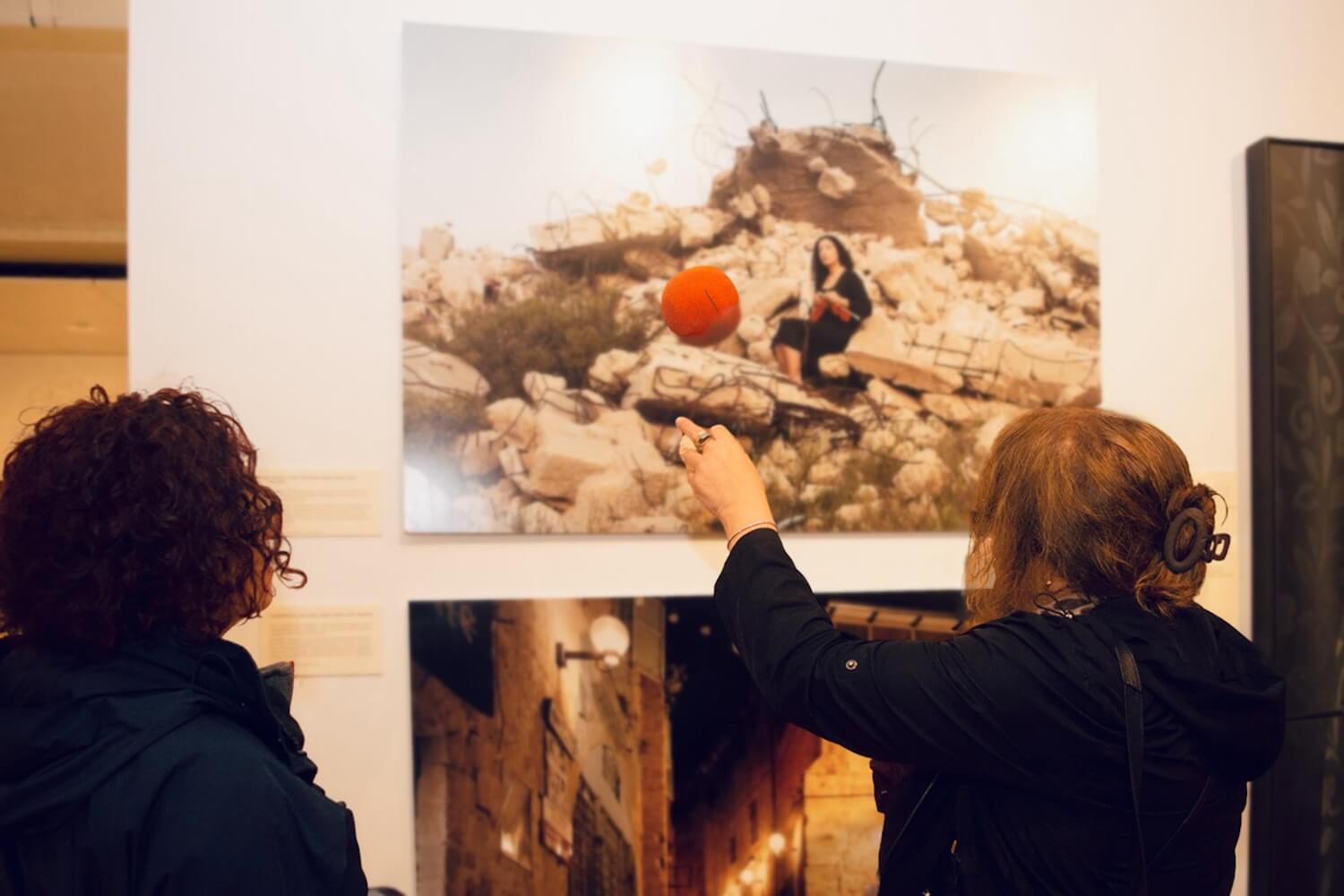 Visitors viewing and discussing Palestinian artwork at a SOAS gallery exhibition.