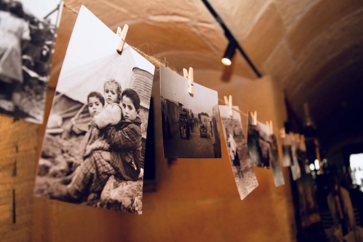 Historic black-and-white photographs of Palestinian life hanging on a display line.