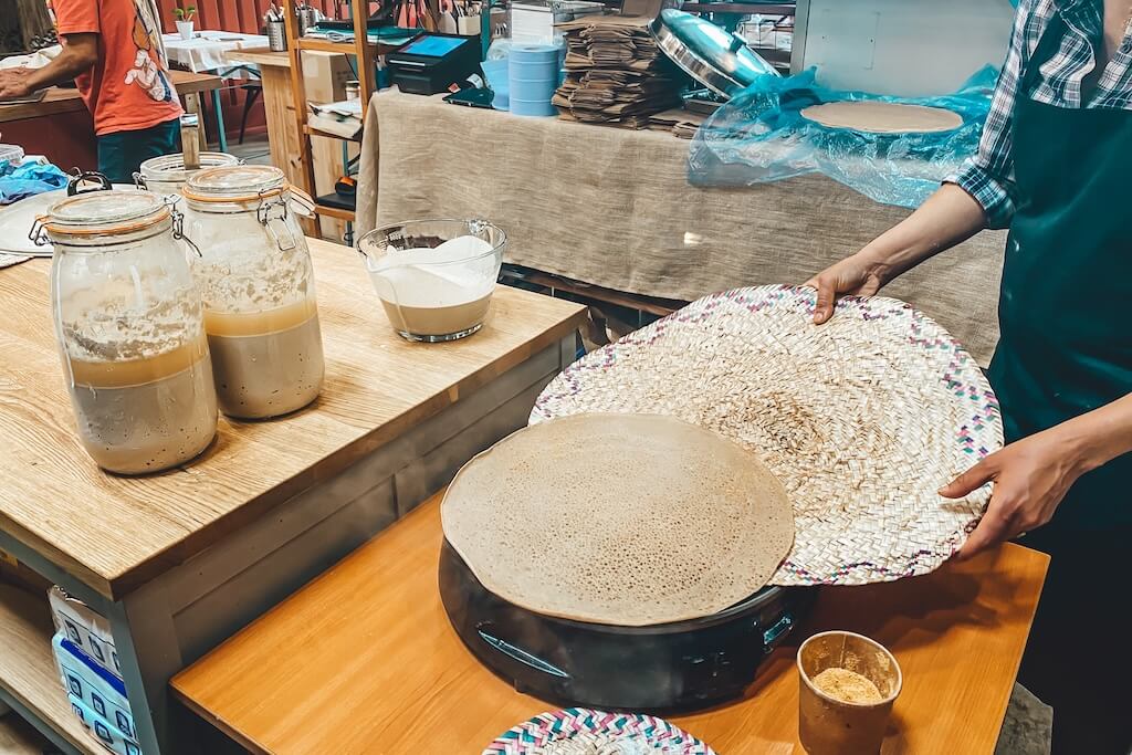 Inside the kitchen at an Ethiopian coffee shop in London where local chefs are preparing traditional dishes for you to try on this tour.