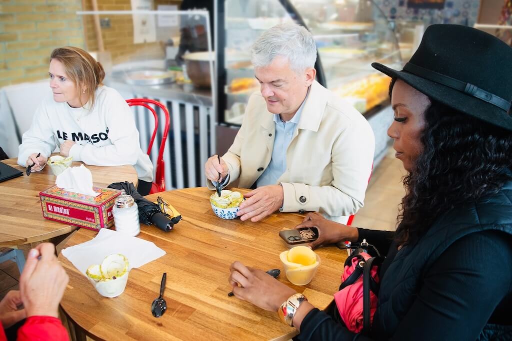 Tour participants enjoying bowls of traditional Arabic ice cream inside a Levantine café.