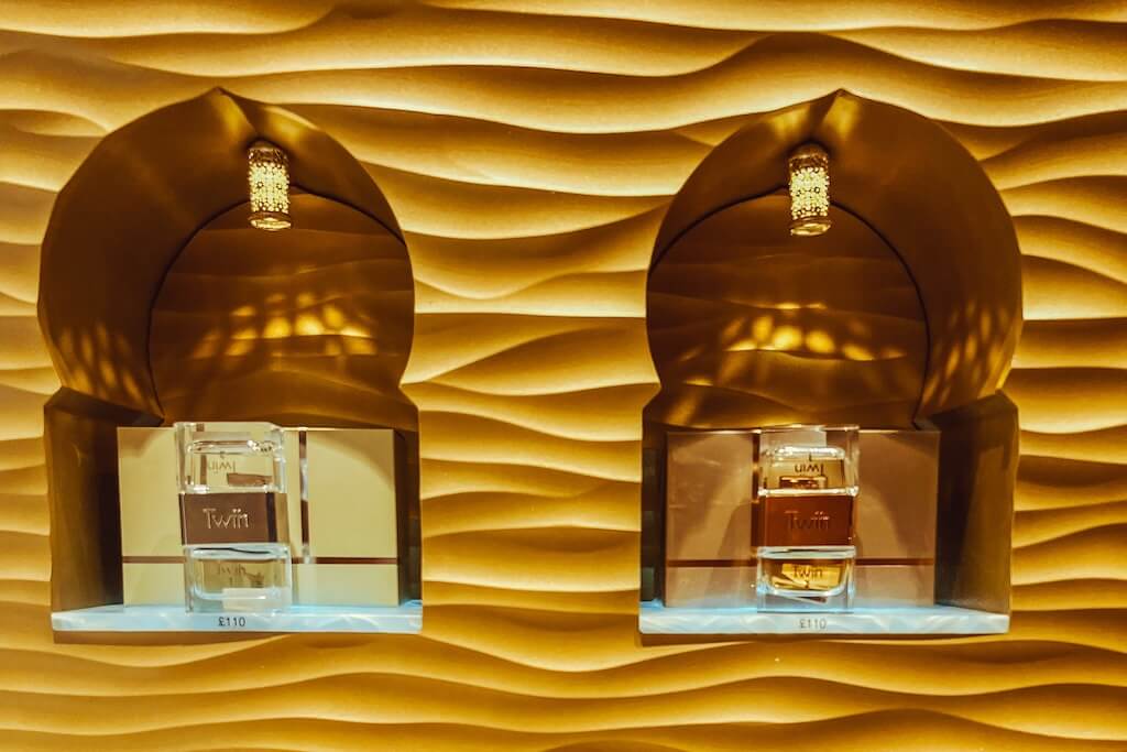 Two perfumes on display on a serrated wall inside a Saudi perfume shop that we visit on this tour.