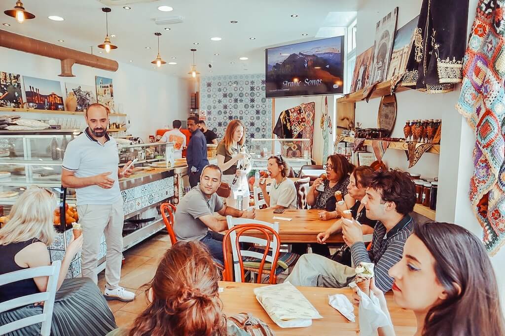 Guests on the Syrain Heritage tour sitting inside a traditional Syrian ice cream parlour in London, enjoying a delicious local ice cream.