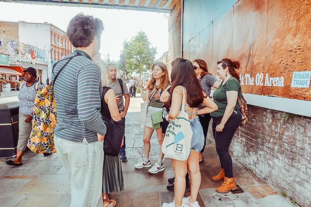 An expert local tour guide talking to her group of guests during the Syrian Heritage Tour of London, explaining the context behind the Syrian community living there.