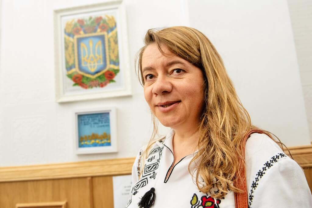 Your local tour guide, Nataliya, standing inside the Ukrainian Community Centre, talking about Ukrainian history to her group of guests.