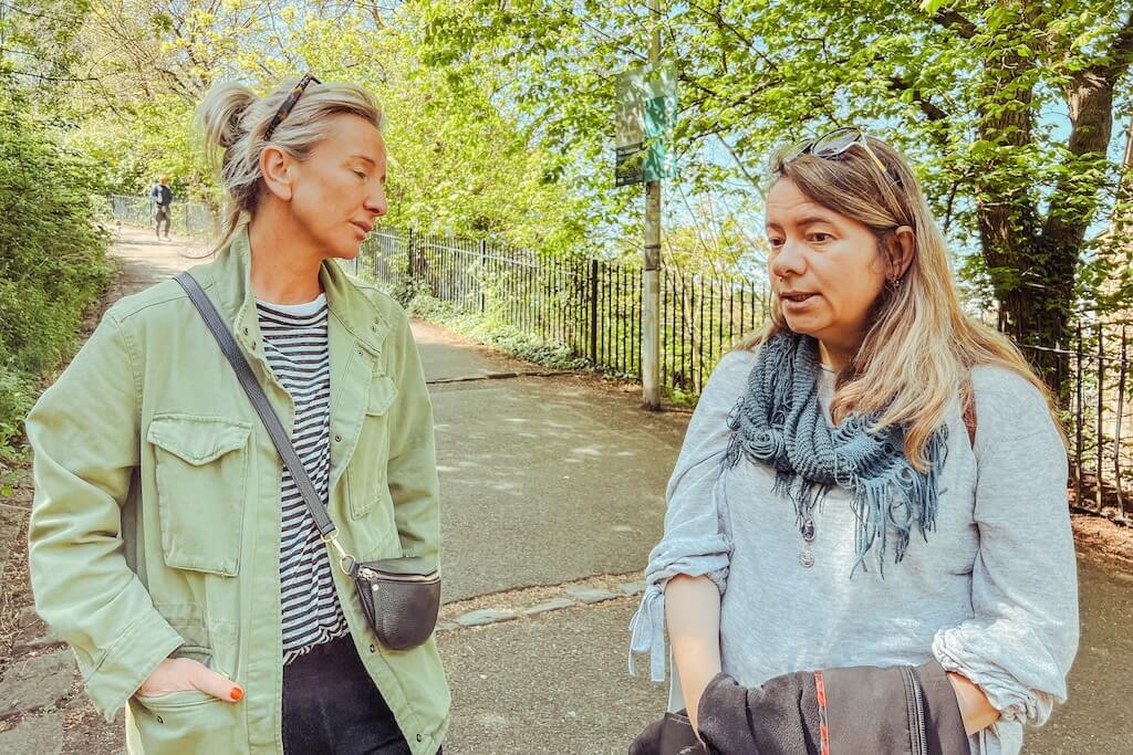 The guide, Natalyia, from Women in Travel, talking to a guest on the Ukrainian Tour of Edinburgh inside a park.