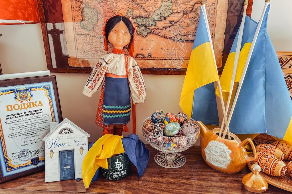 Typical Ukrainian objects and flags on a wooden shelf inside the Ukrainian Community Centre in Edinburgh.
