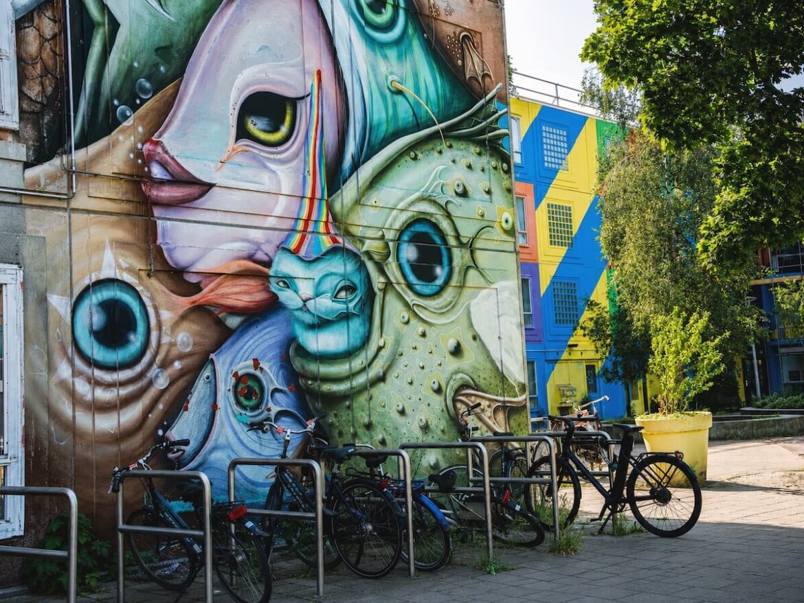 Colourful street art mural with parked bicycles in Amsterdam Zuidoost.