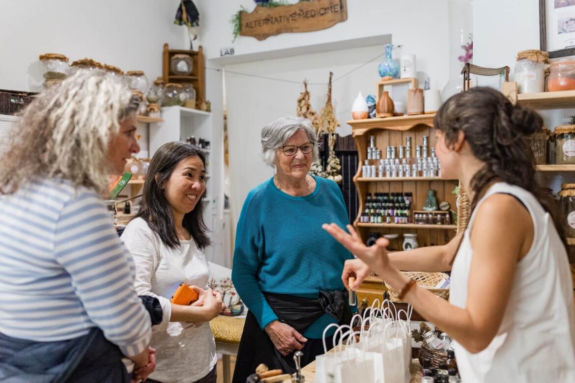 Three tour guests listening to a botanical workshop leader inside Wizadrops in Edinburgh.
