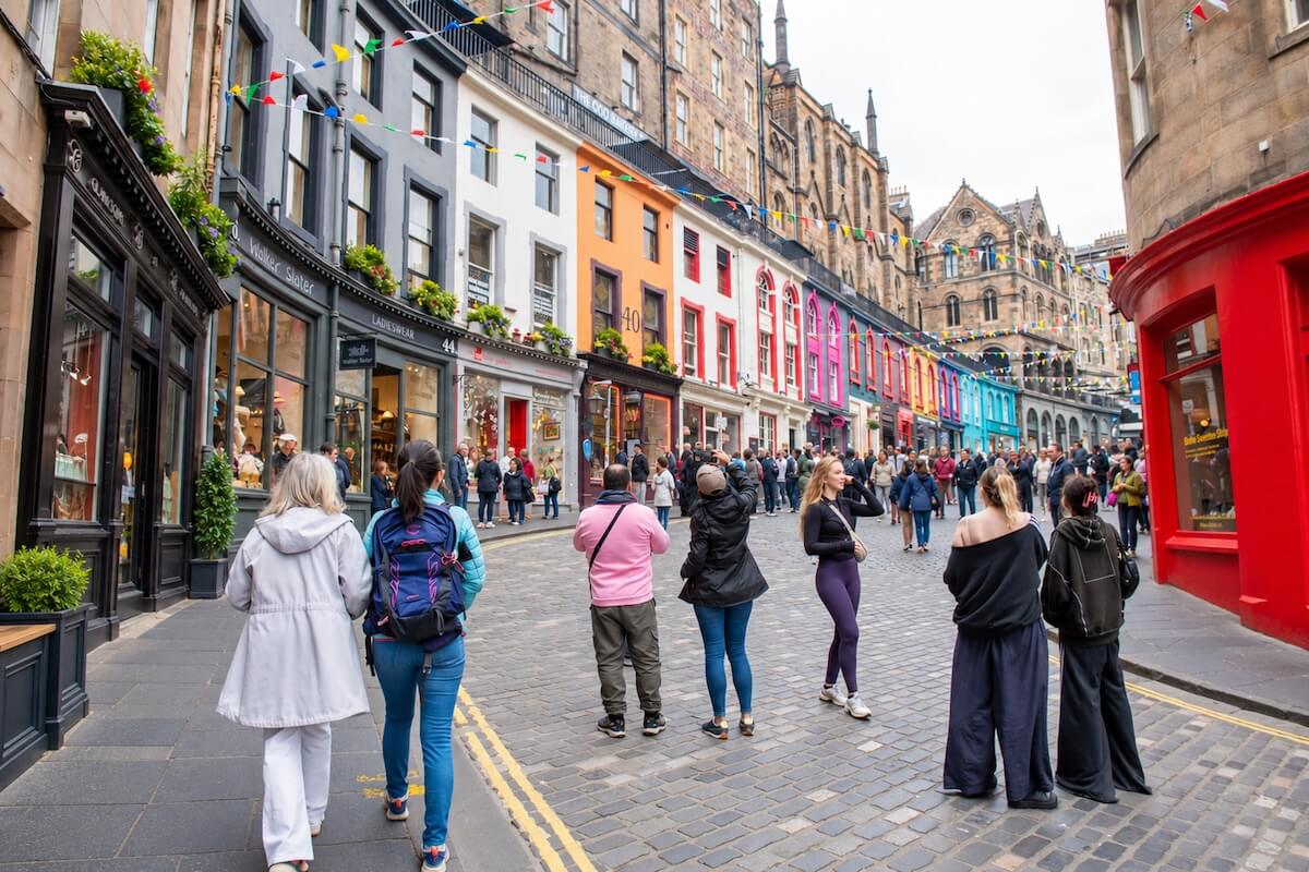 Colourful shopfronts and pedestrians on Victoria Street in Edinburgh’s Old Town