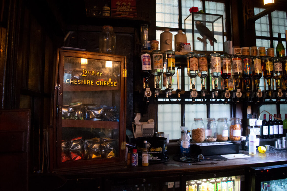 Historic London pub bar with spirits and old signage featured on a food history tour through the city.