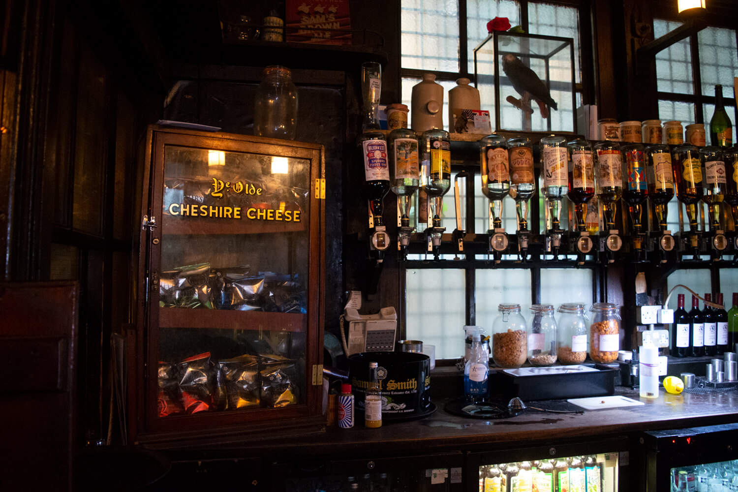 Historic London pub bar with spirits and old signage featured on a food history tour through the city.