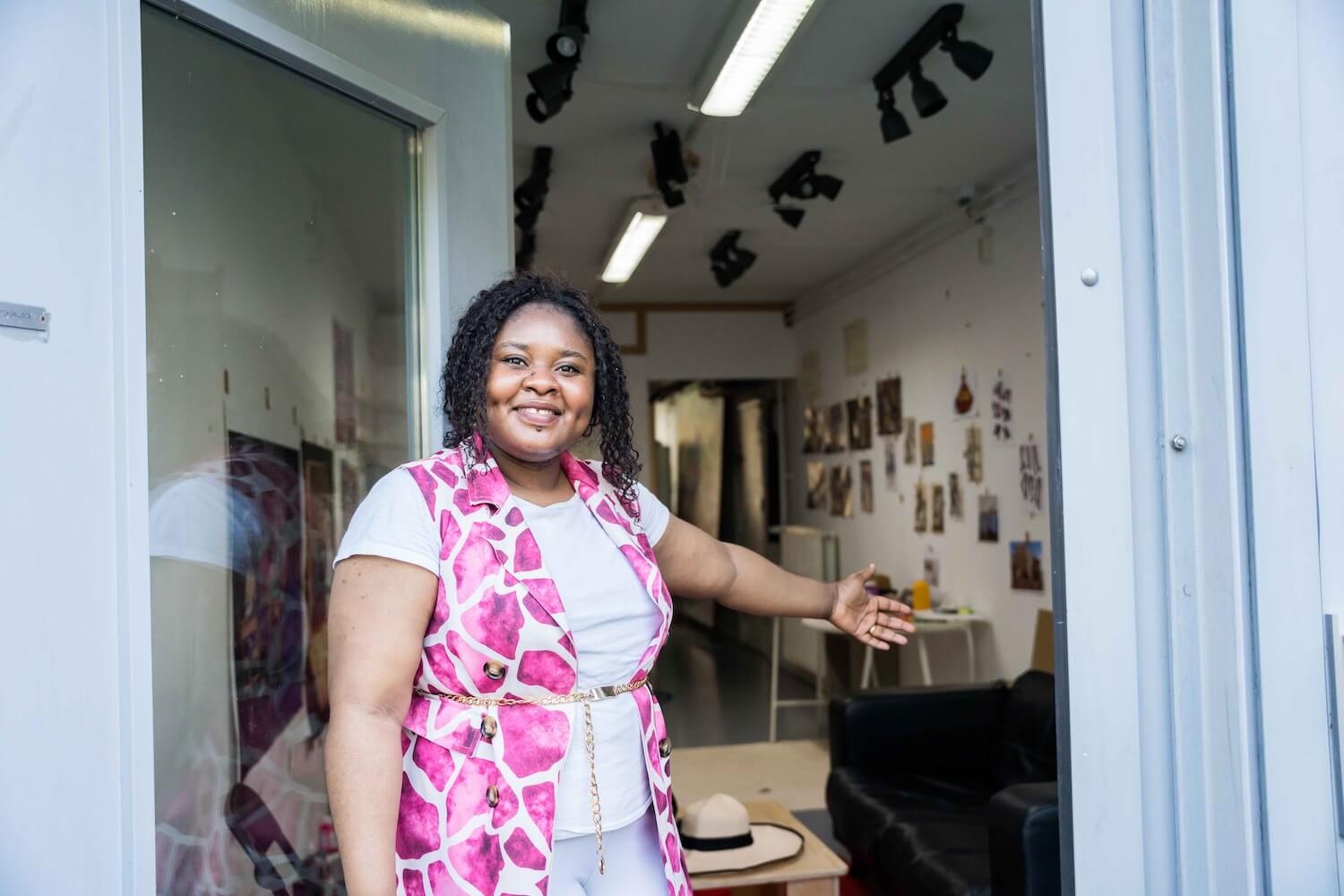 Tour guide welcoming visitors at the entrance to an art studio and gallery in Amsterdam Zuidoost.
