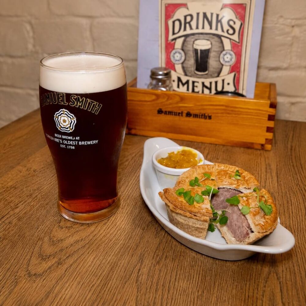 Traditional pork pie with mustard and a glass of ale on the Empire on a Plate tour in London.
