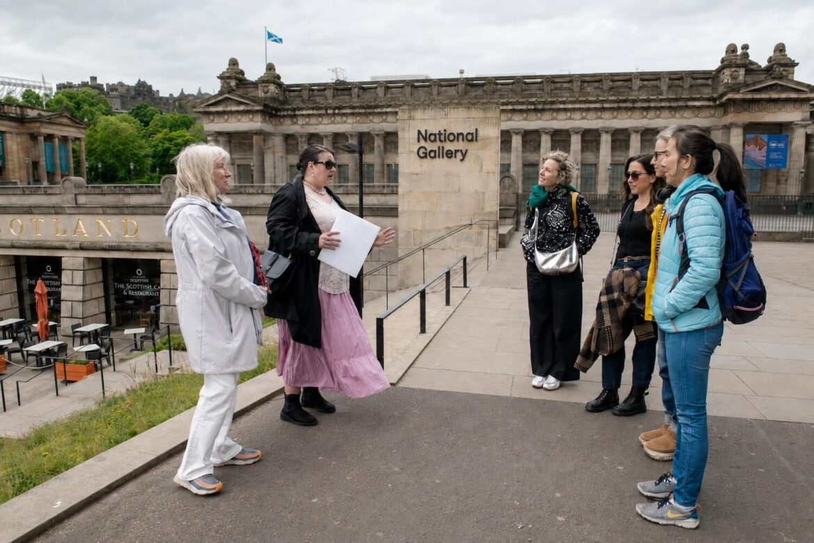 Guide speaking with guests outside the Scottish National Gallery in Edinburgh