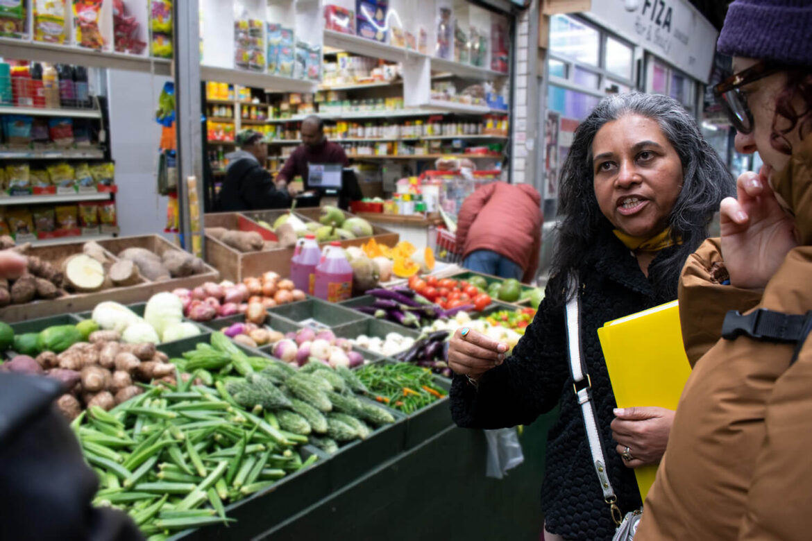 Ranji guiding a guest through Tooting Market on a Sri Lankan food tour in London