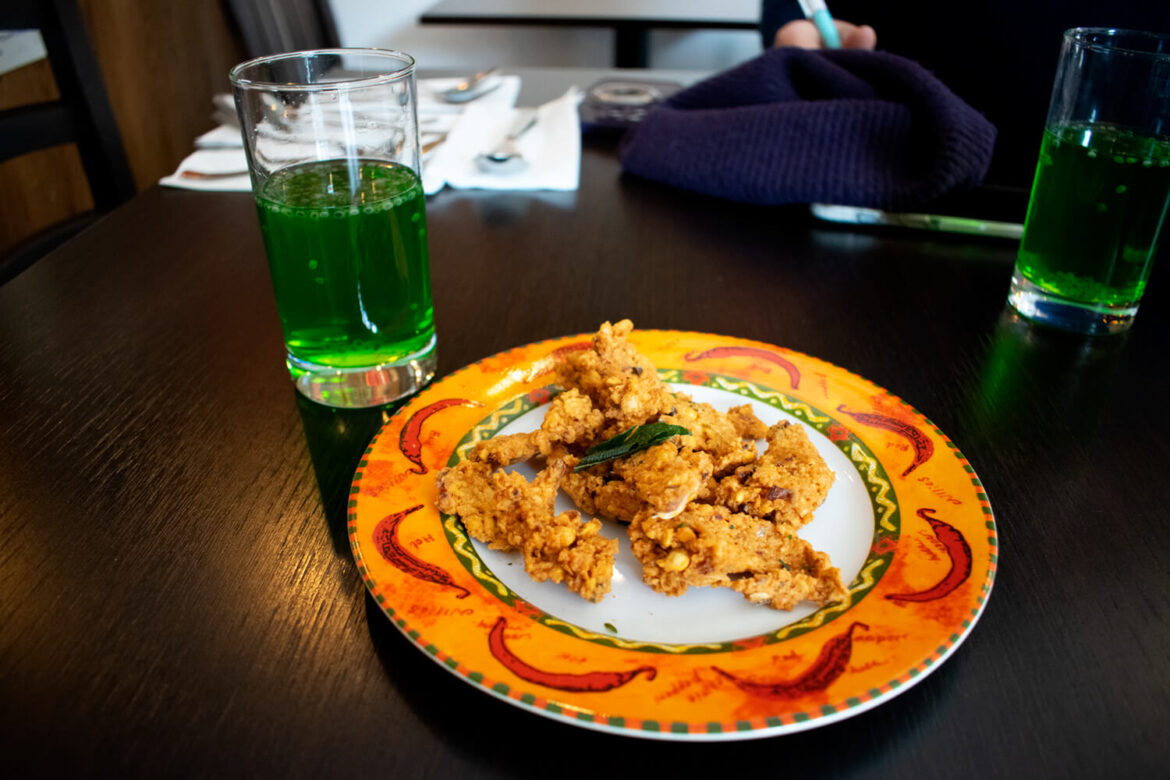 Sri Lankan snack served with bright green drinks during a food tasting
