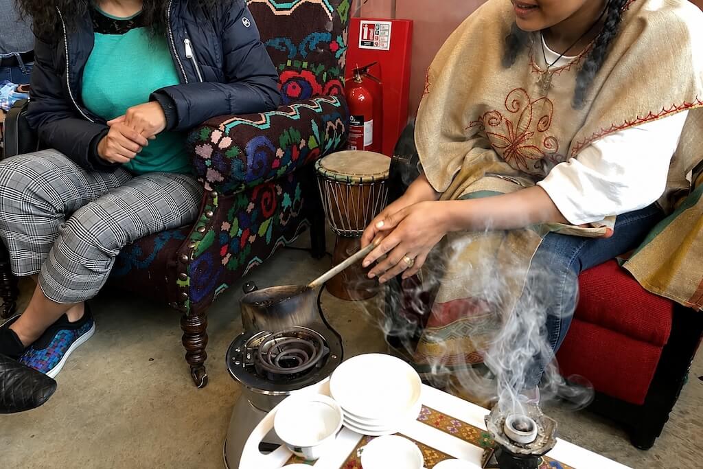 A guide roasting coffee beans during a traditional Ethiopian coffee ceremony in London.