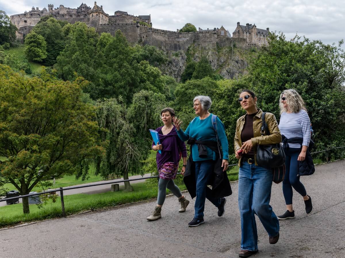 Women walking below Edinburgh Castle on a guided tour.