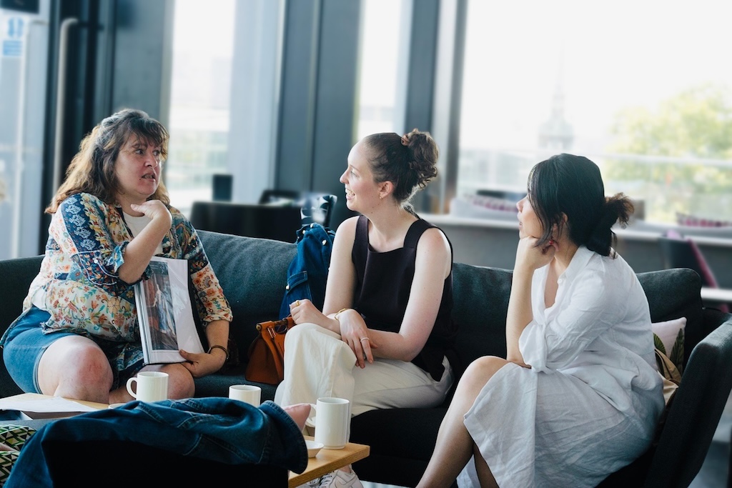 A local tour guide, Florbela, with Iberian heritage, showing her guests images relating to the Iberian minority in London over a cup of tea.