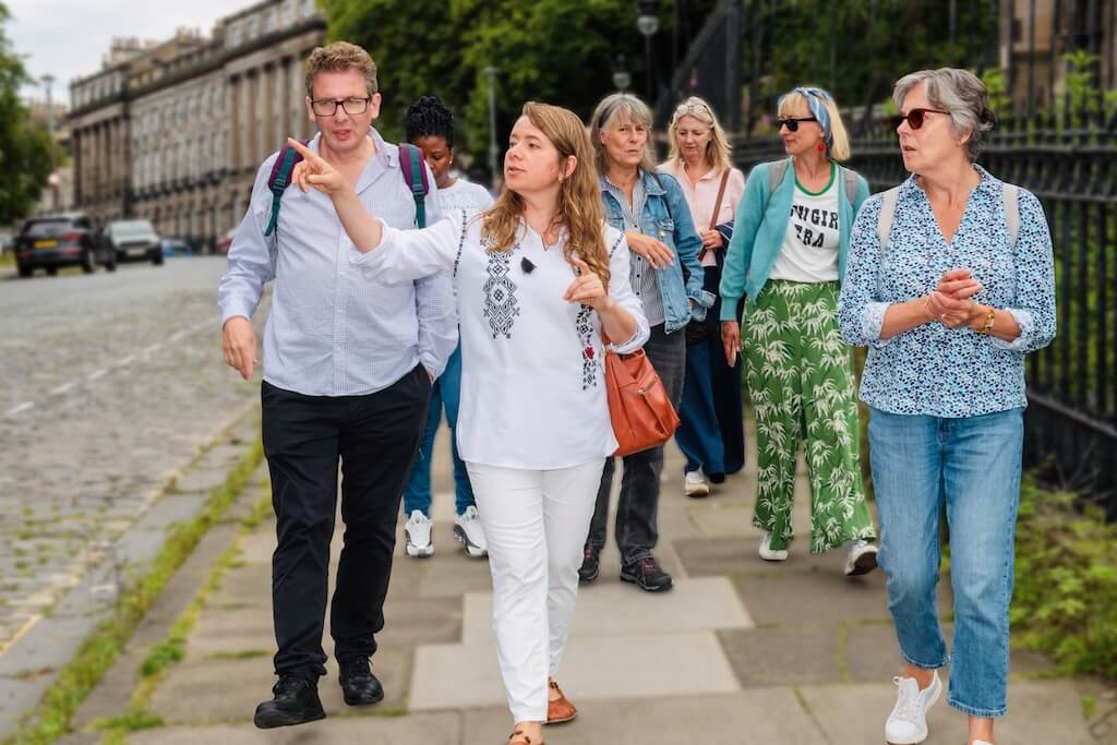 Your local tour guide, Nataliya, leading a group of guests on the Ukrainian Tour through the streets of Edinburg, pointing out objects related to Ukrainian culture and heritage.